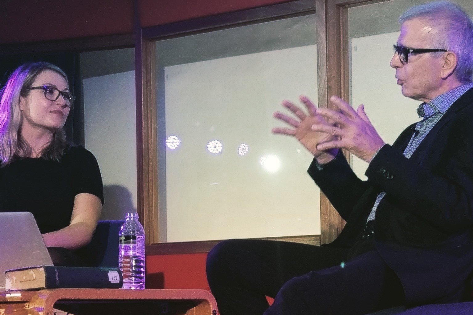 Tony Visconti in conversation with Leah Kardos on stage in the live room, talking with his hands