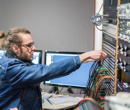 An engineer patching signals in the control room