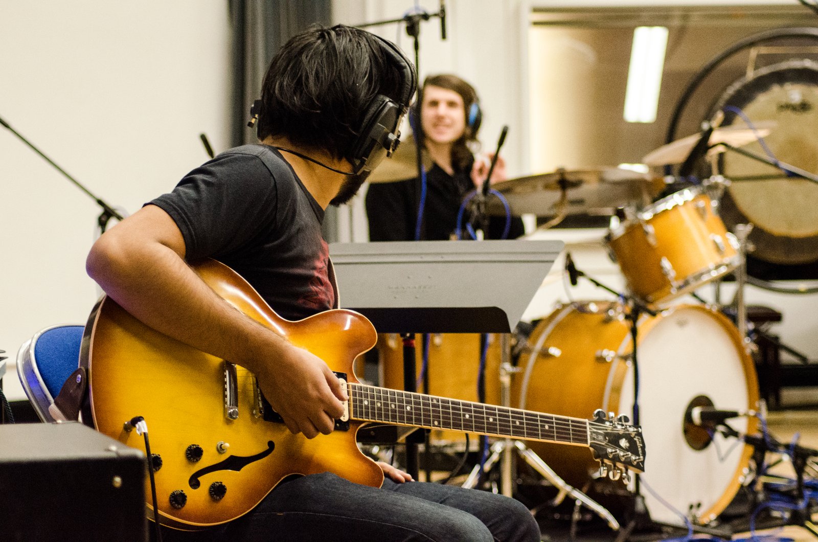 A guitarist and drummer tracking live together in the live room