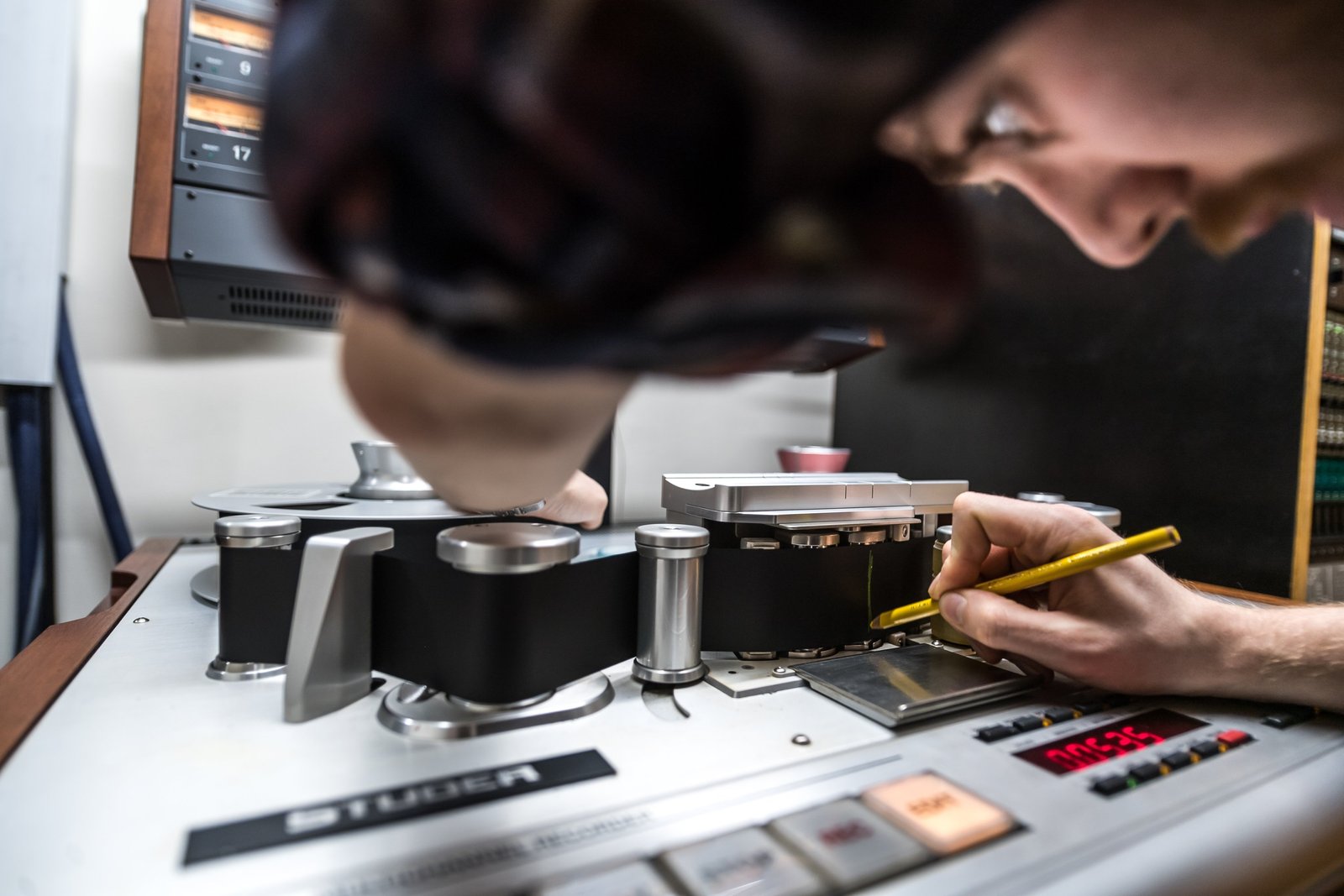Hands marking a splice on 2-inch tape with a pencil