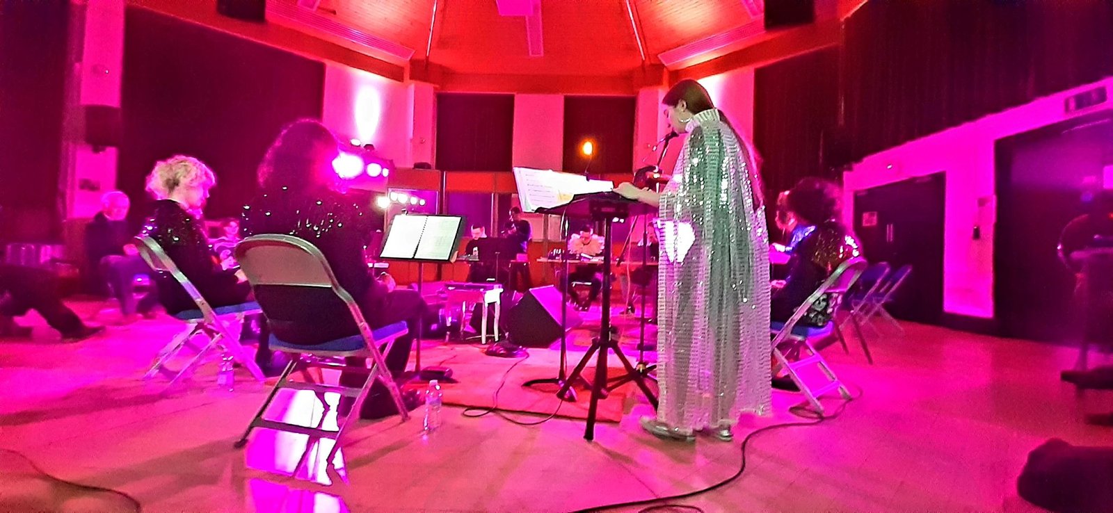 The Kingston University Stylophone Orchestra performing in the live room, in the round, under pink gel lights
